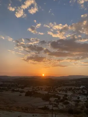 a sunset over a town with the sun in the sky at Sunset Retreat Cyprus in Pendakomo