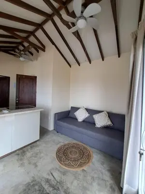 a living room with a blue couch and a kitchen at Sunset Retreat Cyprus in Pendakomo