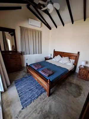 a bedroom with a large bed with a blue blanket at Sunset Retreat Cyprus in Pendakomo