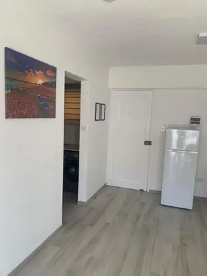 an empty living room with a refrigerator and a door at Prestige Worldwide Apartments in Ayia Napa