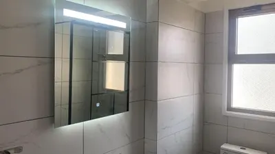 a bathroom with a glass shower with a window at Prestige Worldwide Apartments in Ayia Napa
