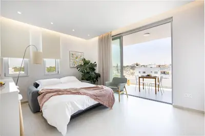 a bedroom with a bed and a table and a balcony at Rodoni Residence in Strovolos