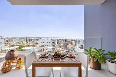a dining room with a table and chairs and a view at Rodoni Residence in Strovolos