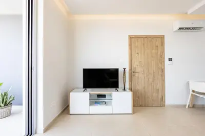 a living room with a tv and a door at Rodoni Residence in Strovolos