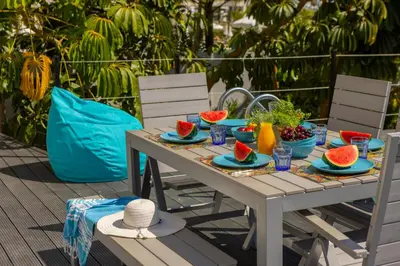 a table with watermelon plates and bowls of fruit on it at Protaras Sunrise Zen Seafront Villa in Protaras