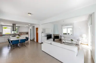 a living room and kitchen with a couch and a table at Protaras Sunrise Zen Seafront Villa in Protaras