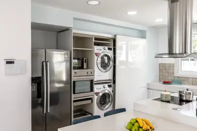 a kitchen with a refrigerator and washing machines at Protaras Sunrise Zen Seafront Villa in Protaras