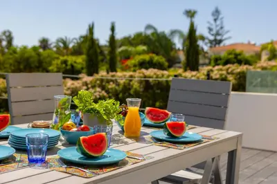 a table with plates of fruit and juice on it at Protaras Sunrise Zen Seafront Villa in Protaras