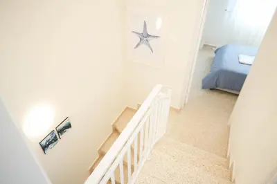 a staircase in a bedroom with a starfish on the wall at Ocean Blue House 17 in Meneou