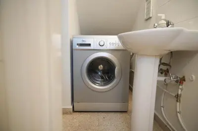 a washing machine in a bathroom next to a sink at Ocean Blue House 17 in Meneou