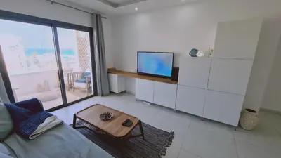 a living room with a couch and a tv and a table at STAY Kallucci's maison de la mer in Larnaka