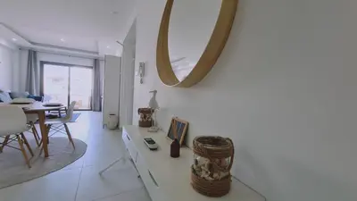 a white living room with a table and a mirror at STAY Kallucci's maison de la mer in Larnaka