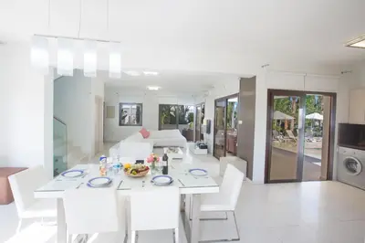 a white dining room and living room with a table and chairs at Demetra Villa in Ayia Napa
