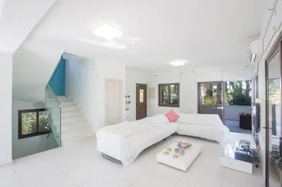 a white living room with a couch and a table at Demetra Villa in Ayia Napa