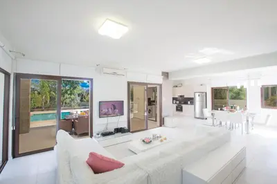 a living room with white furniture and a kitchen at Demetra Villa in Ayia Napa
