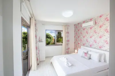 a bedroom with a white bed and a window at Demetra Villa in Ayia Napa