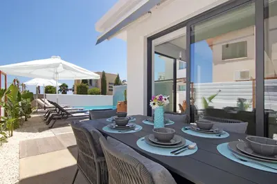 a black table with chairs and flowers on a patio at Votsalo Villa - 30m from Med Sea in Ayia Napa
