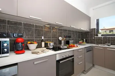 a kitchen with white counter tops and appliances at Votsalo Villa - 30m from Med Sea in Ayia Napa