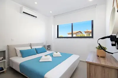 a bedroom with a large bed and a window at Votsalo Villa - 30m from Med Sea in Ayia Napa