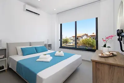 a bedroom with a large bed and a large window at Votsalo Villa - 30m from Med Sea in Ayia Napa