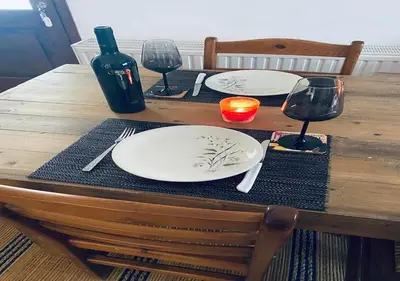 a wooden table with two white plates and wine glasses at Vavatsinia Panorama Cottage in Vavatsinia