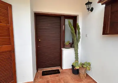a hallway with a wooden door and a potted plant at Vavatsinia Panorama Cottage in Vavatsinia