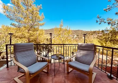 two chairs and a table on a balcony with a view at Vavatsinia Panorama Cottage in Vavatsinia