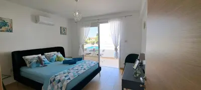 a bedroom with a bed with a view of the ocean at Nissi 3 Pool View Apartment in Ayia Napa