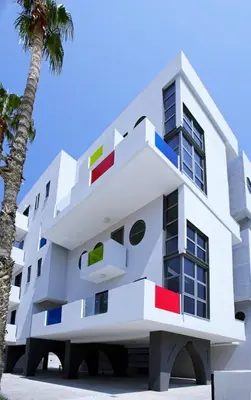 an image of a white building with a palm tree at Alex Residence in Larnaka