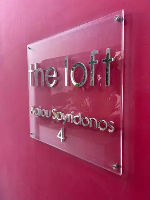 a sign on a pink wall that says the hotagents at Alex Residence in Larnaka