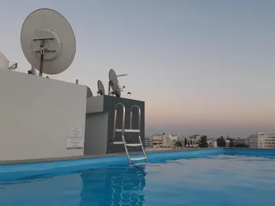 a chair sitting on the edge of a swimming pool at Alex Residence in Larnaka