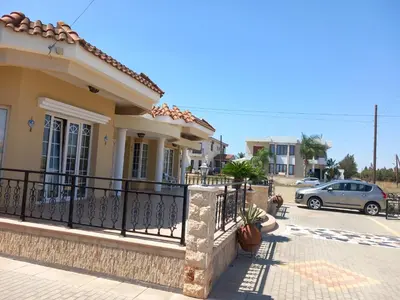 a house with a fence in front of a street at Vasilis House family room in Larnaka