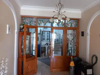 a hallway with a wooden door and a chandelier at Vasilis House family room in Larnaka