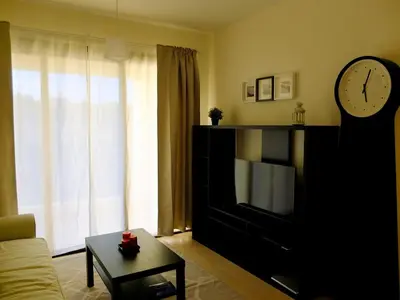 a living room with a tv and a clock at Tersefanou Traditional Village Larnaca in Larnaka