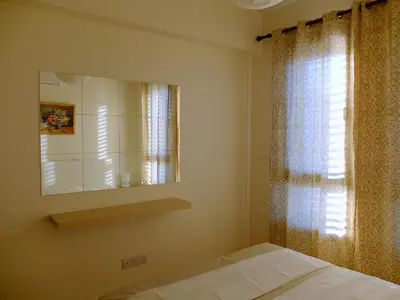 a bedroom with a mirror and a bed and a window at Tersefanou Traditional Village Larnaca in Larnaka