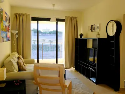 a living room with a couch and a clock at Tersefanou Traditional Village Larnaca in Larnaka