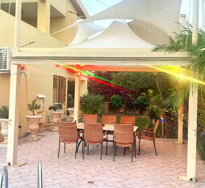 a patio with a table and chairs under a pavilion at Villa Victoria Ayia Napa in Ayia Napa