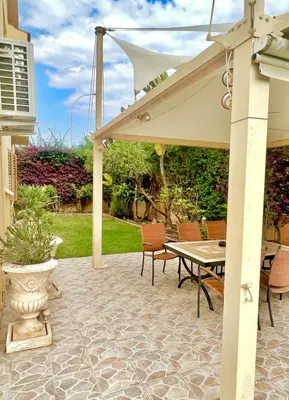 a patio with a table and chairs and an umbrella at Villa Victoria Ayia Napa in Ayia Napa