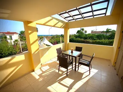 a patio with a table and chairs on a balcony at Villa Victoria Ayia Napa in Ayia Napa