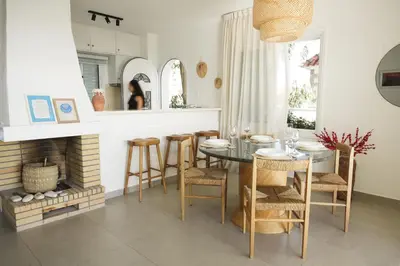 a dining room with a table and chairs and a fireplace at Meneou Houses by the Sea in Larnaka