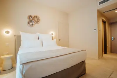 a bedroom with a large white bed with white pillows at Thymises Boutique Hotel in Kakopetria