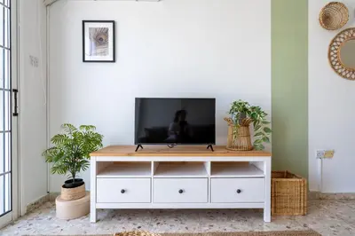 a living room with a tv on a white dresser at Blossom 1-Bedroom Apartment in Larnaca in Larnaka