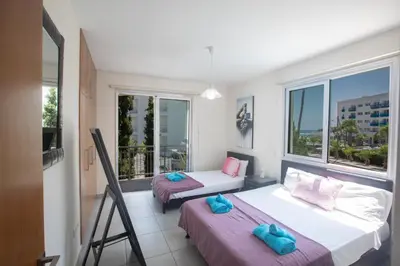 two beds in a room with a balcony at Pelagos Villa 8 in Protaras
