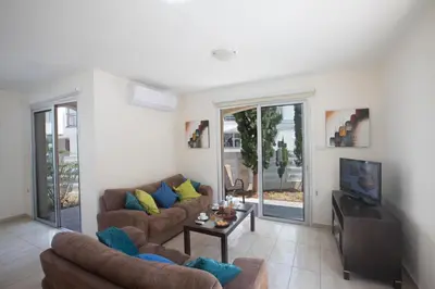 a living room with two couches and a tv at Pelagos Villa 8 in Protaras