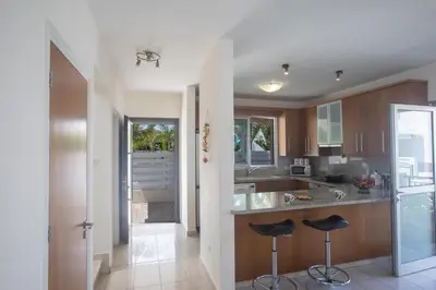 a kitchen with a counter and two stools in it at Pelagos Villa 8 in Protaras
