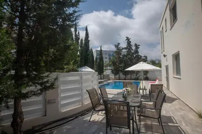 a patio with a table and chairs next to a pool at Pelagos Villa 8 in Protaras