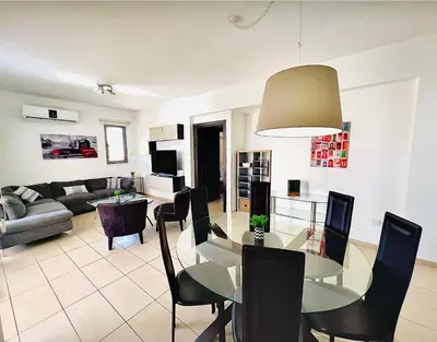 a dining room and living room with a table and chairs at LARA 303 in Larnaka