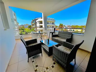 a balcony with chairs and a table and a large window at LARA 303 in Larnaka