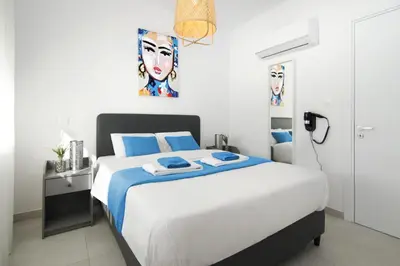 a bedroom with a large white bed with blue sheets at Villa Amazonia - Large Private Pool in Protaras
