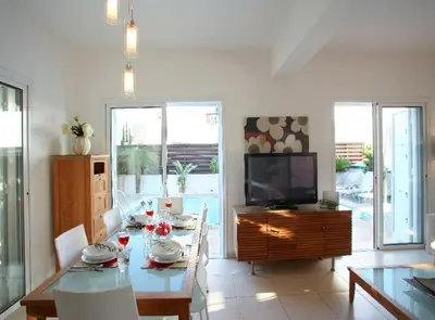 a living room with a table and a television at Villa Kos 19 in Protaras